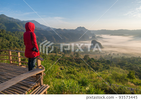 Asian woman travel in Phu Lung ka forest park during the sunrise in Phayao province of Thailand. Asian woman travel in Phu Lung ka forest park during the sunrise in Phayao province of Thailand. 93573445