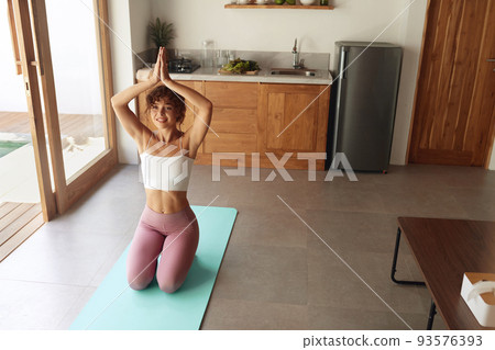Yoga At Home. Woman In Easy Pose Warming Up Before Exercising Yoga At Home. Woman In Easy Pose Warming Up Before Exercising 93576393