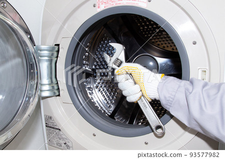 Worker with washing machine and wrench 93577982