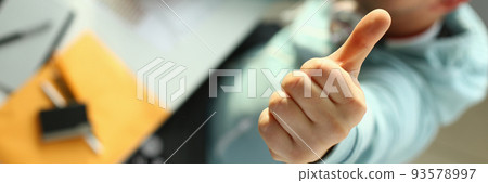 Young designer holding thumb up gesture closeup Young designer holding thumb up gesture closeup 93578997