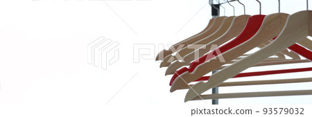 Red and wooden hanger hanging from metal pipe Red and wooden hanger hanging from metal pipe 93579032