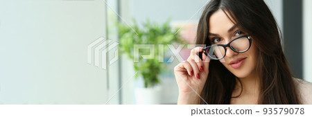 Beautiful smiling fashionable businesswoman holds glasses closeup Beautiful smiling fashionable businesswoman holds glasses closeup 93579078