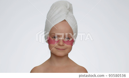 Smiling child girl applying pink patches under eyes, teenager natural skin care, perfect fresh clean Smiling child girl applying pink patches under eyes, teenager natural skin care, perfect fresh clean 93580536