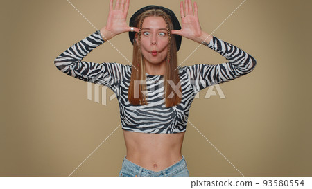 Funny woman making playful silly facial expressions and grimacing, fooling around, showing tongue Funny woman making playful silly facial expressions and grimacing, fooling around, showing tongue 93580554