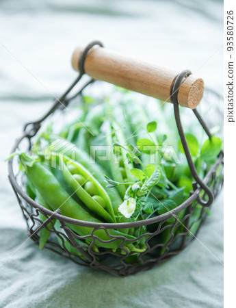 Basket with sweet pea pods 93580726