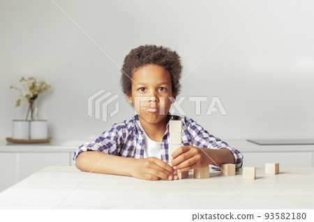 Cute african american child boy playing wooden toys at home Cute african american child boy playing wooden toys at home 93582180