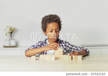 Kid and wooden house and blocks. Child playing at home Kid and wooden house and blocks. Child playing at home 93582183