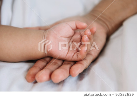 Close up baby hand on mother's hands. Close up baby hand on mother's hands. 93582659