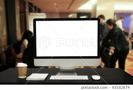 Front view of Computer monitor  cup and computer laptop, smartphone, and tablet on table in meeting room 93582674