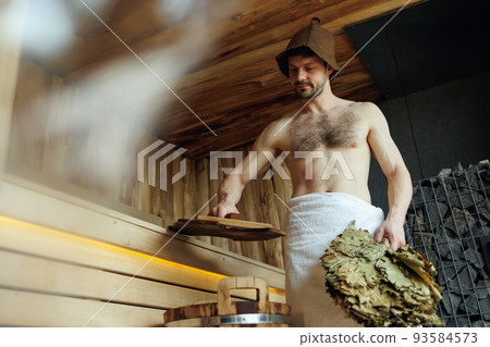 Man relaxing in sauna during vacation at spa resort 93584573