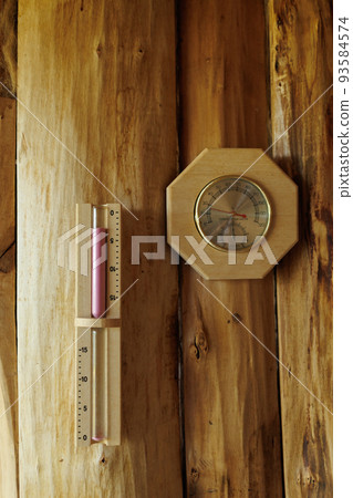 Sauna thermometer and hygrometer, hourglass on wooden wall 93584574