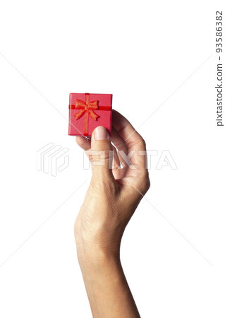 woman hand handing over a red gift box woman hand handing over a red gift box 93586382