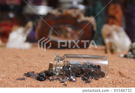 Bottle of Chakra Stones on Red Sand With Agatized Coral in Background Bottle of Chakra Stones on Red Sand With Agatized Coral in Background 93586732