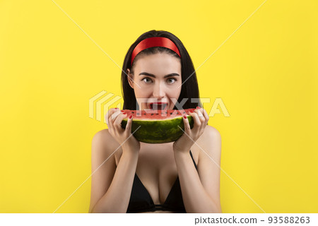 Photo of a beautiful woman with a watermelon posing on a yellow background. Photo of a beautiful woman with a watermelon posing on a yellow background. 93588263