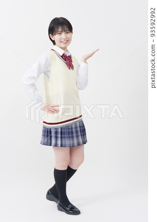 一個高中女生用手掌在白色背景上指向右邊，全身 93592992
