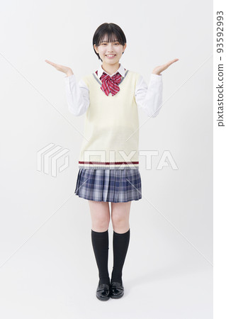 A high school girl who points to both sides with the palm of her hand on a white background. A high school girl who points to both sides with the palm of her hand on a white background. 93592993
