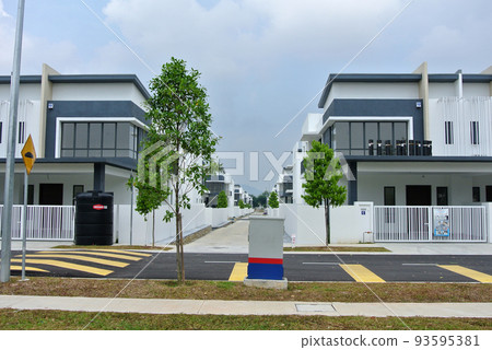SELANGOR, MALAYSIA - JUNE 18, 2022: New double-story terrace house under construction in Malaysia. This house has a wide front porch and is fenced. Has basic facilities. 93595381