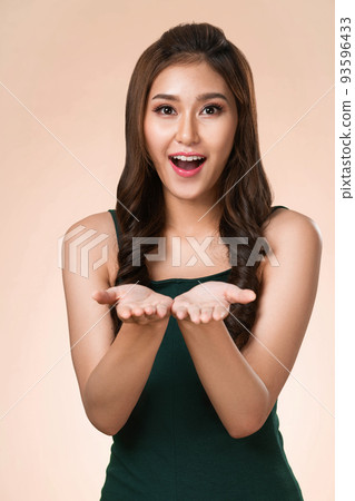 Portrait of ardent woman looking at camera, holding empty space for advertising. Portrait of ardent woman looking at camera, holding empty space for advertising. 93596433