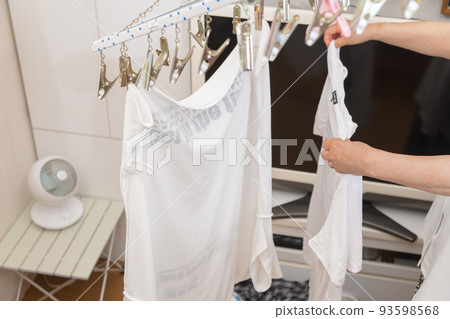 【中間主婦用T卹循環器烘乾衣物的家務場景】 93598568