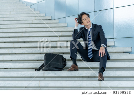 Office worker sitting on the stairs Office worker sitting on the stairs 93599558