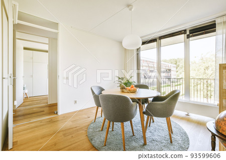 Couch and armchairs placed around table with decorations in dining area of stylish living room in modern flat 93599606