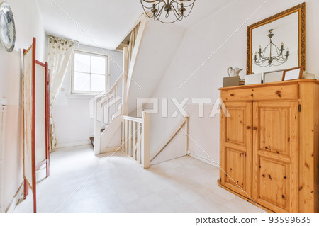 White hallway with wooden stairway leading to second floor of modern luxury apartment with minimalist interior design 93599635