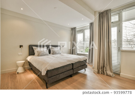 Home interior design of bedroom with bed and wooden wardrobe placed in corner near window in modern apartment Home interior design of bedroom with bed and wooden wardrobe placed in corner near window in modern apartment 93599778