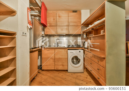 Table with chairs and flowers located near lounge area and kitchen in spacious room of contemporary apartment Table with chairs and flowers located near lounge area and kitchen in spacious room of contemporary apartment 93600151
