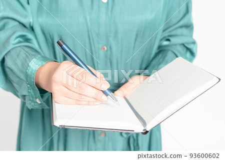 Hands of a woman writing notes in a notebook Hands of a woman writing notes in a notebook 93600602