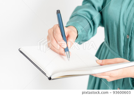 Hands of a woman writing notes in a notebook 93600603