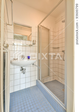 Sinks with mirrors and shower box with glass door in modern bathroom with white tiled walls 93600799