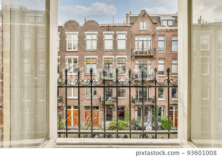 Front view of old brick buildings from small balcony with railings 93601008