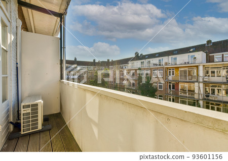 Panoramic view of old brick buildings with parking and trees from small balcony 93601156