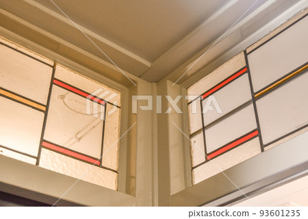 Close up of beautiful stained glass window with ornament and unusual shapes in luxury apartment Close up of beautiful stained glass window with ornament and unusual shapes in luxury apartment 93601235