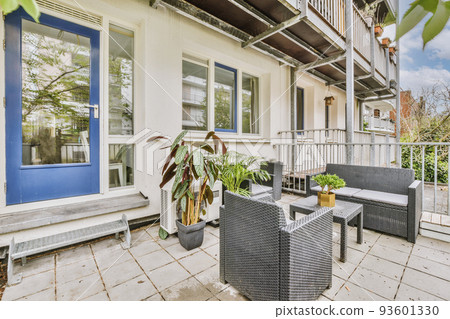 Neat paved patio with sitting area and small garden near wooden fence Neat paved patio with sitting area and small garden near wooden fence 93601330