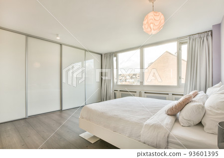Home interior design of bedroom with bed and wooden wardrobe placed in corner near window in modern apartment Home interior design of bedroom with bed and wooden wardrobe placed in corner near window in modern apartment 93601395