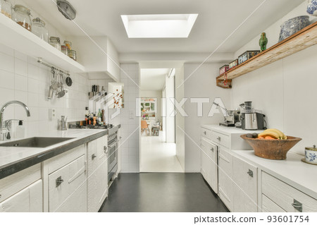 Contemporary counters and stools located under stylish exhaust hood in spacious light kitchen at home Contemporary counters and stools located under stylish exhaust hood in spacious light kitchen at home 93601754