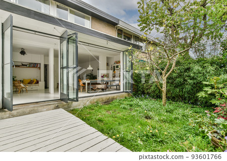 Neat paved patio with sitting area and small garden near wooden fence Neat paved patio with sitting area and small garden near wooden fence 93601766