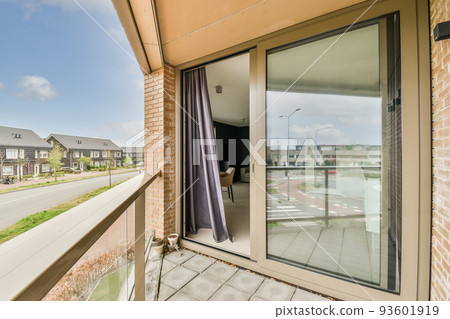 Front view of old brick buildings and cars with bicycles from small balcony with railings 93601919