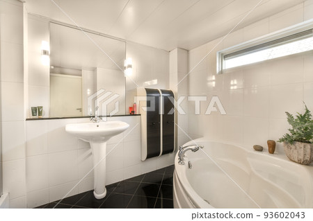 Glass partition between shower tap and wall hung toilet in modern restroom at home 93602043