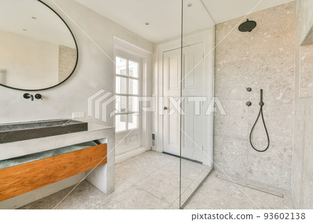 Sinks with mirrors and clean bathtub located near shower box with glass door in modern bathroom with white tiled walls Sinks with mirrors and clean bathtub located near shower box with glass door in modern bathroom with white tiled walls 93602138