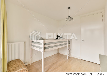 Interior of white room with baby crib and armchair near window with blue chest of drawers in daylight 93602367
