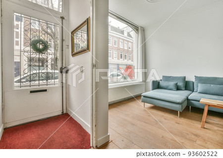 Comfortable sofa with cushions placed against light wall with TV and decorations in modern loving room Comfortable sofa with cushions placed against light wall with TV and decorations in modern loving room 93602522