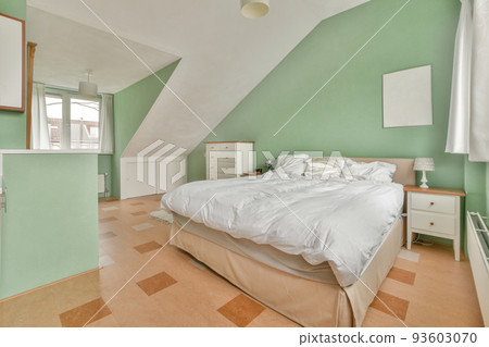 Home interior design of bedroom with bed and wooden wardrobe placed in corner near window in modern apartment 93603070