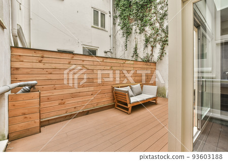 Neat paved patio with sitting area near wooden fence 93603188