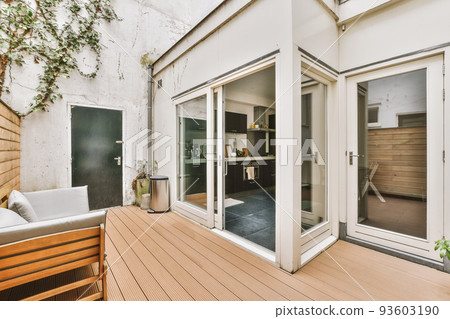 Neat paved patio with sitting area near wooden fence 93603190