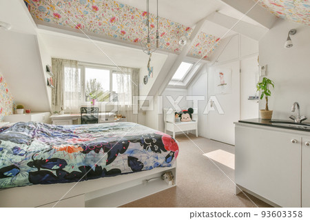 Home interior design of bedroom with bed and wooden wardrobe placed in corner near window in modern apartment 93603358