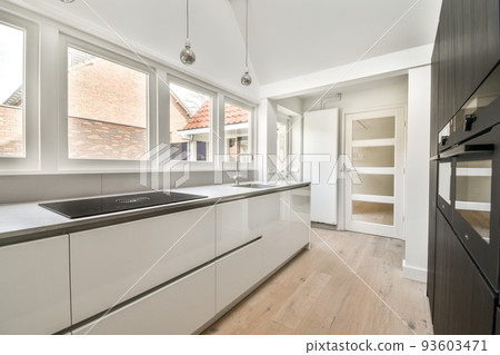 Counter with chairs dividing kitchen with modern furniture from dining area in contemporary flat Counter with chairs dividing kitchen with modern furniture from dining area in contemporary flat 93603471