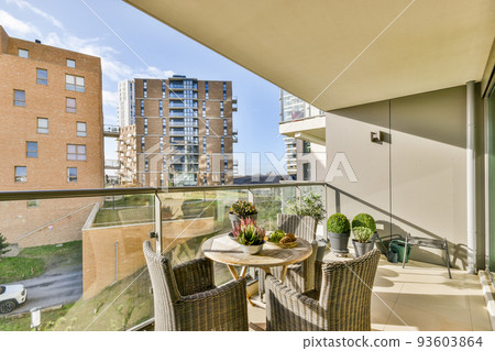 Sitting area in balcony with comfortable furniture around beautiful view 93603864