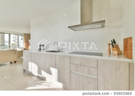 Interior of light kitchen and dining room with balcony doors in contemporary apartment at daytime 93603868